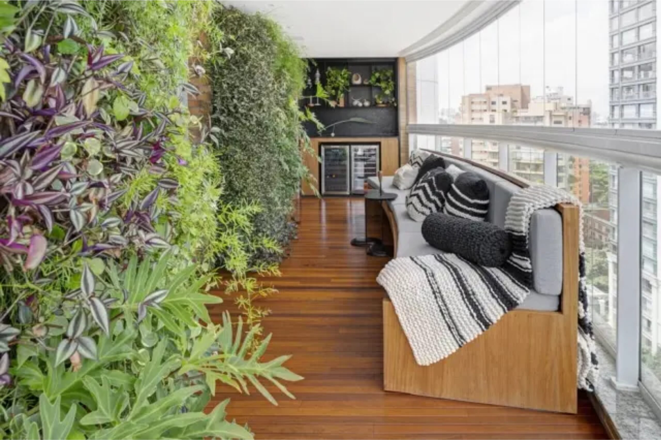Imagem de uma sala com sofá e jardim vertical