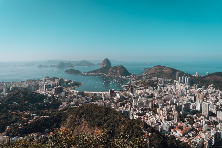A landscape of Rio De Janeiro surrounded by the sea under a blue sky in Brazil