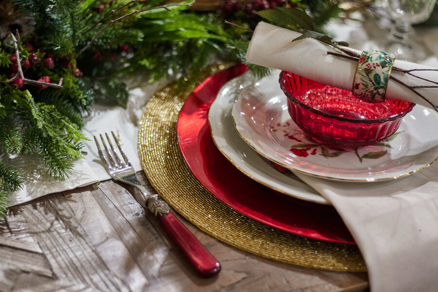 A high angle shot of Christmas dinner set up with glasses and ornaments on a table