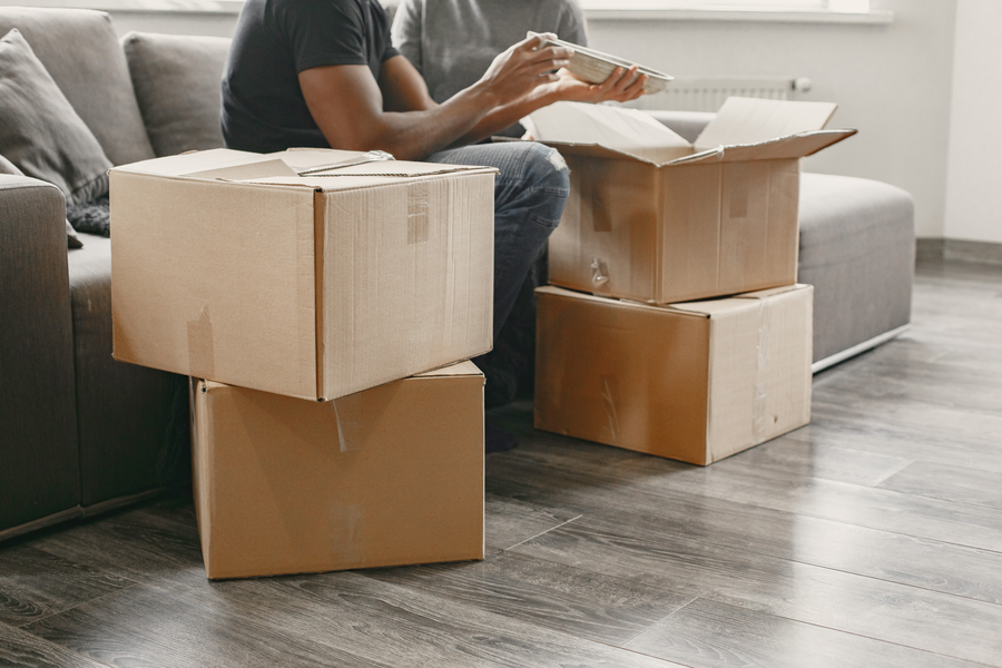portrait-of-young-couple-with-cardboard-boxes-at-new-home-moving-house-concept
